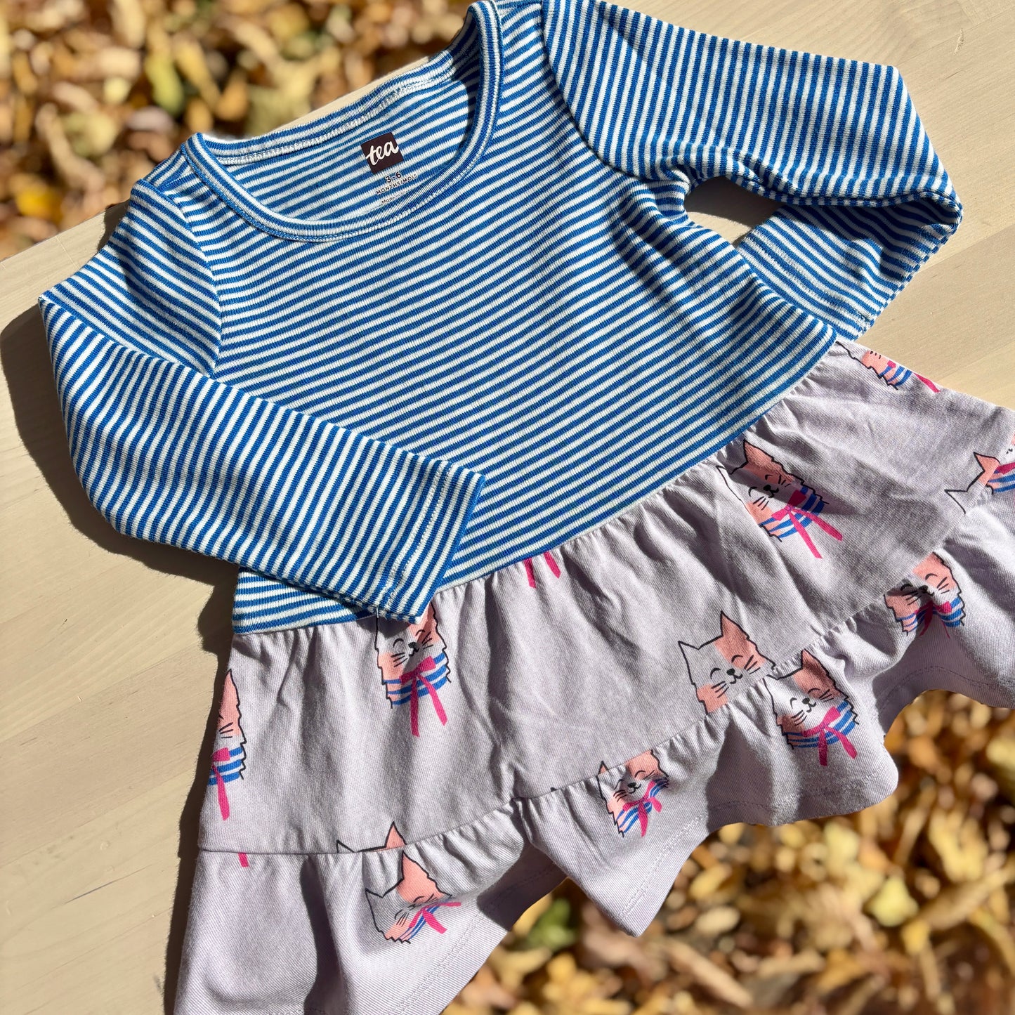 Children's blue and white striped dress with purple cat pattern 

