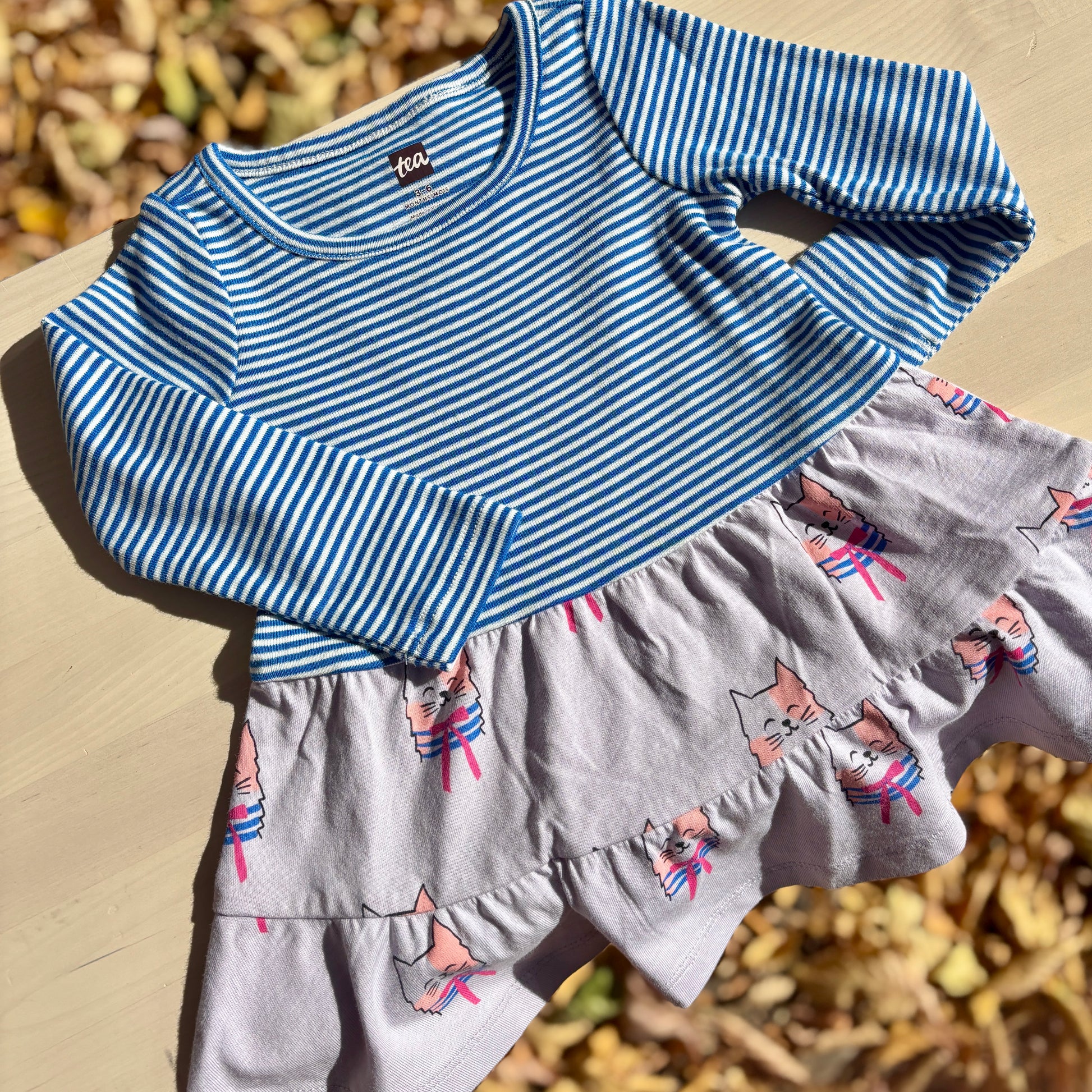 Children's blue and white striped dress with purple cat pattern 

